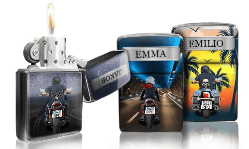 Three Zippo lighters with custom designs: one lit with a night highway scene, another showing a rider with 