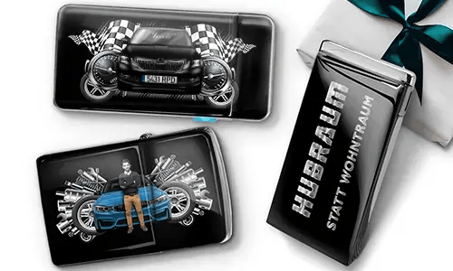 Geschenkset mit Auto-Themen-Metallbehältern, die Bilder eines grünen Sportwagens, karierten Flaggen und Motor-Motiven zeigen. Enthält ein Zigarettenetui mit der Aufschrift „Hubraum Statt Wohntraum“.