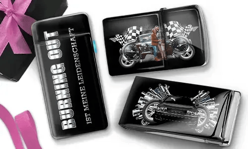 Drei glänzende Zigarettenetuis mit Automotiv. Eines trägt die Aufschrift „Burning Out Ist Meine Leidenschaft“. Die anderen zeigen ein Motorrad und ein Sportauto mit karierten Flaggen.