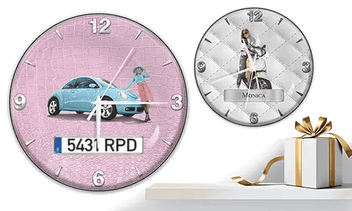 Two wall clocks with female figures and vehicles: left with black car on purple waves, right with red and black cars, racing flags, and blue background