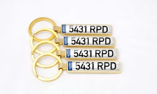 Gold license plate keychains display personalized numbers arranged together