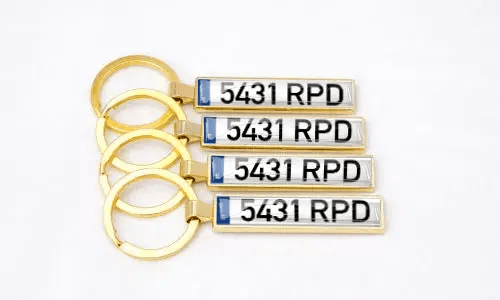Gullfargede metallnøkkelringer med nummerskilt fremhever personlige biltilbehør