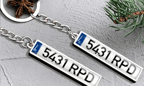 Metallinen avaimenperä, jossa rekisterikilpi ja lippudetalji