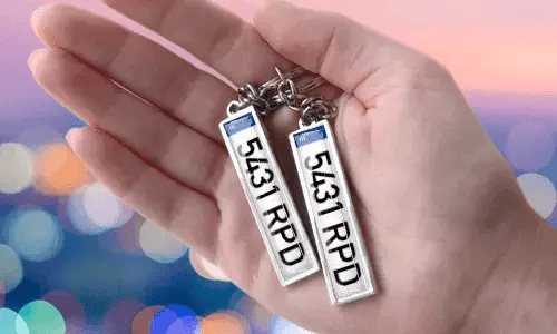 Porte-clés avec plaque personnalisée et numéros personnalisés, tenu en main