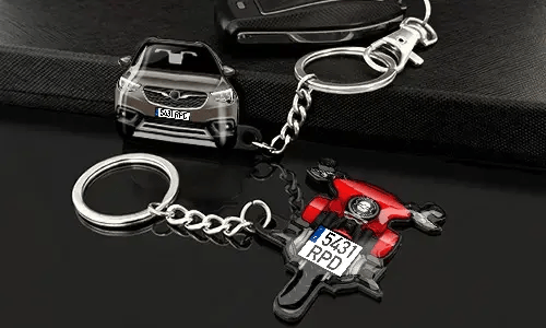 Car and motorcycle keychains displayed with detailed vehicle designs