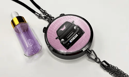 Pendant with pink background and white sports car, next to purple dropper bottle with gold cap