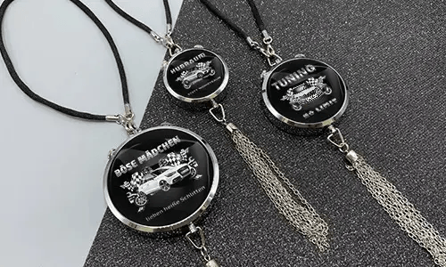 Three black pendants with chains: each with car graphic and German tuning slogan on glittery surface