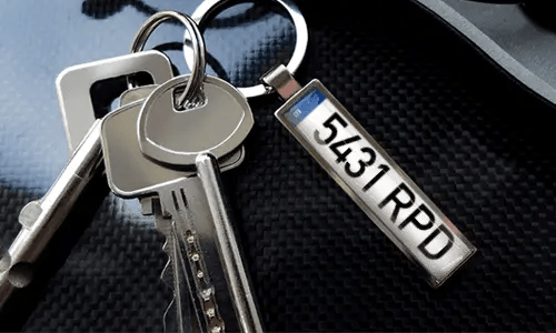 Portachiavi con pendente illustrato con auto e anello in metallo