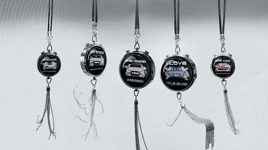 Five round keychains with German car-themed slogans and illustrations, hanging in a row