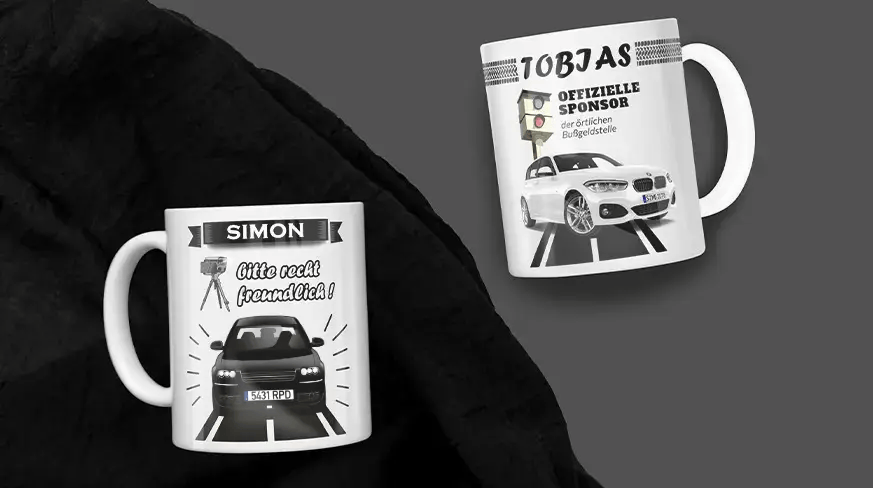 Zwei weiße Tassen mit Auto- und Blitzer-Motiven: Simons Tasse mit freundlicher Botschaft, Tobias' Tasse mit humorvollem Bußgeldtext